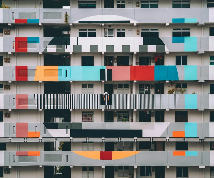 a building with multiple colorful windows next to some bushes