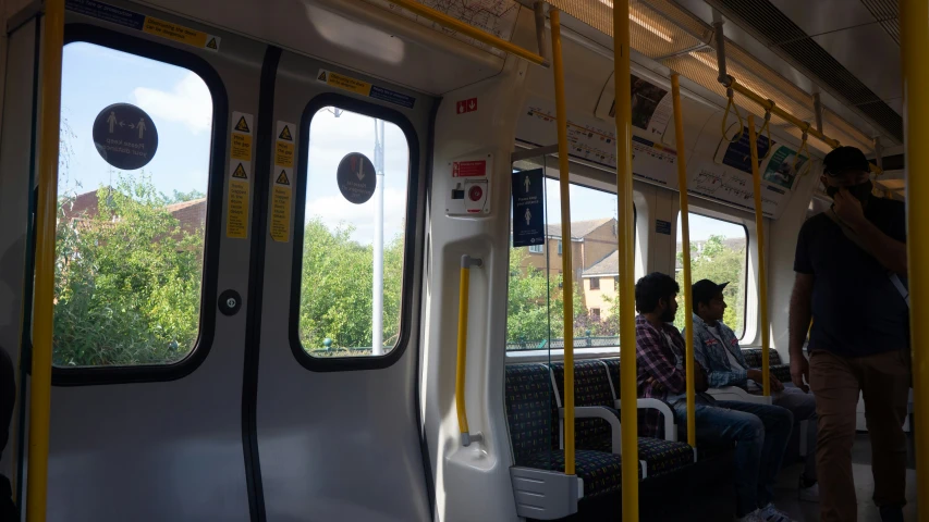 three men inside a passenger train looking out the windows