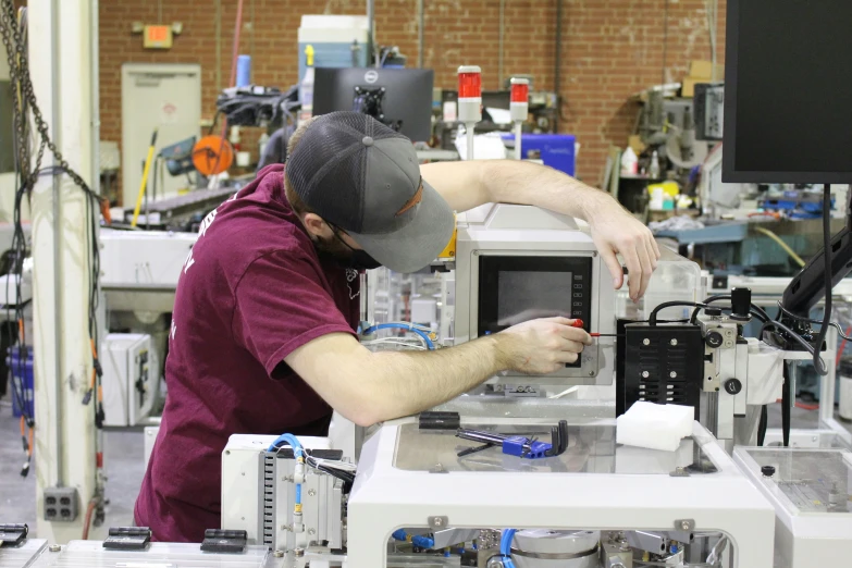 two workers are working on a piece of machinery