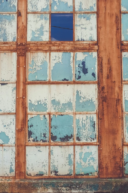 an old window with some windows missing, and rusted