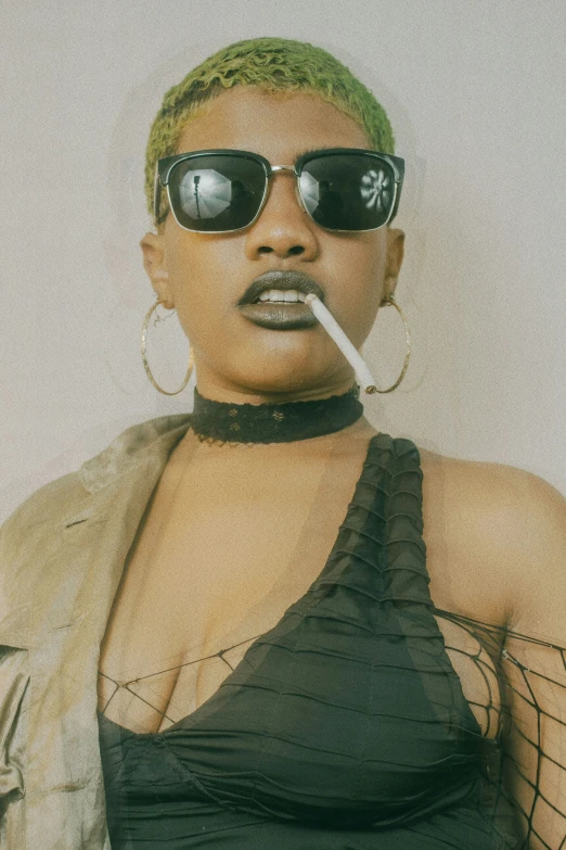 a woman in sunglasses smokes a cigarette