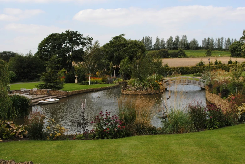 there is a pond and bridge in the middle of the field