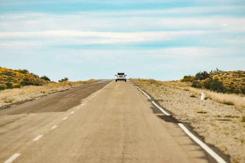 a long straight road that has a truck on it