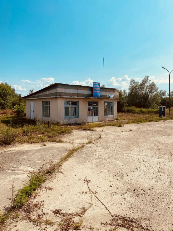 an old building in the dirt on a sunny day