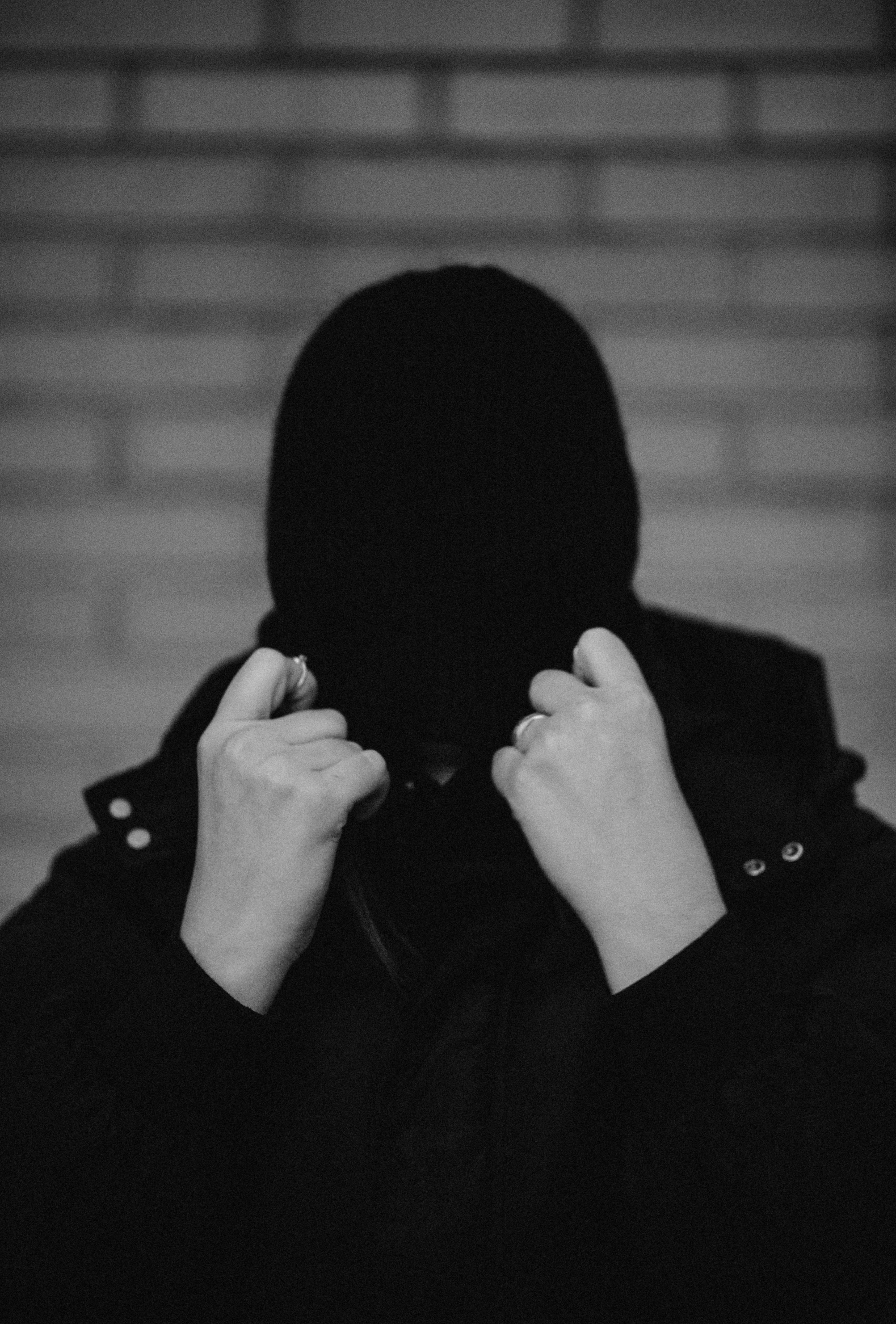 a person hiding their face behind a coat