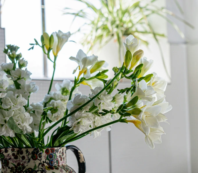 a vase full of flowers is sitting on the window sill