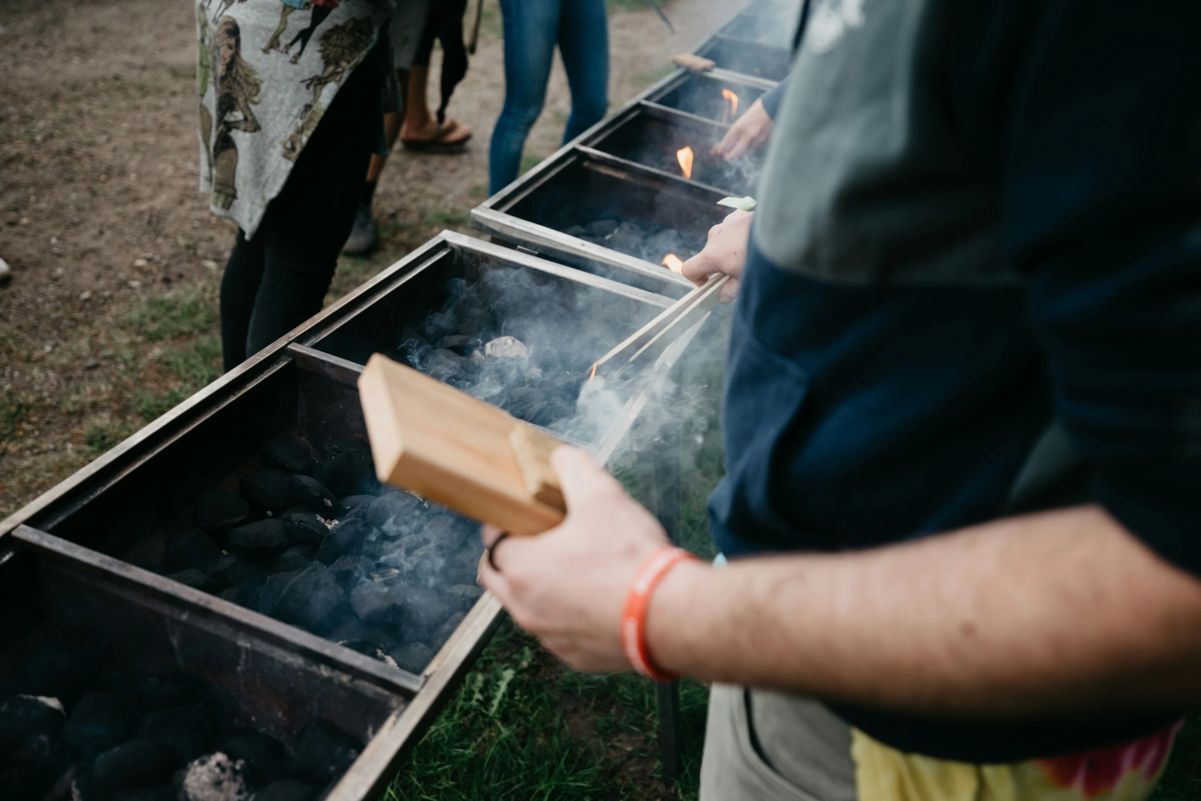 a person standing near another man cooking food