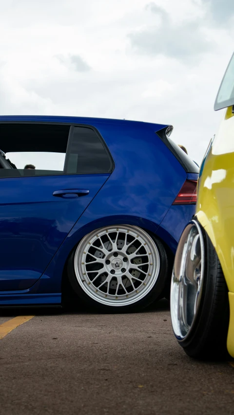 the back end of a blue car with white tires