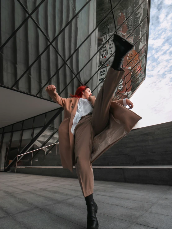 woman with red hair, wearing a brown suit and black boots