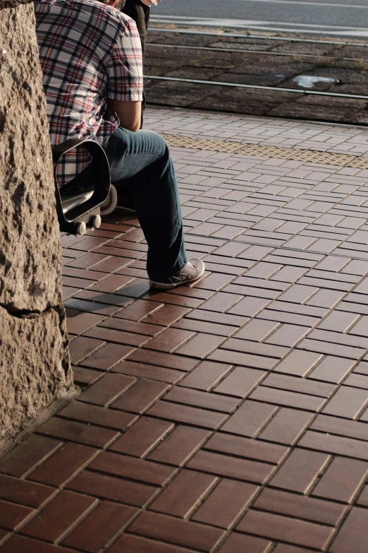 a man sitting on a bench holding a skateboard