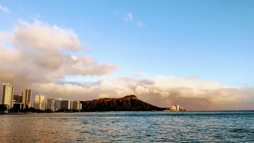 a view of buildings and water with a mountain in the background