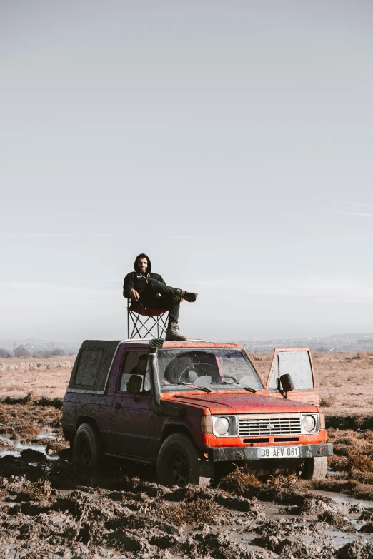 a man sitting on the top of an old truck