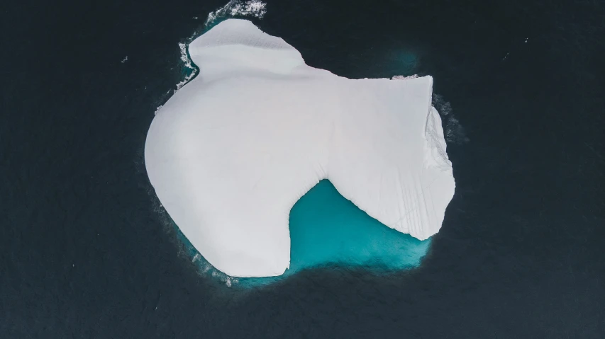 an aerial view of a large iceberg floating in water