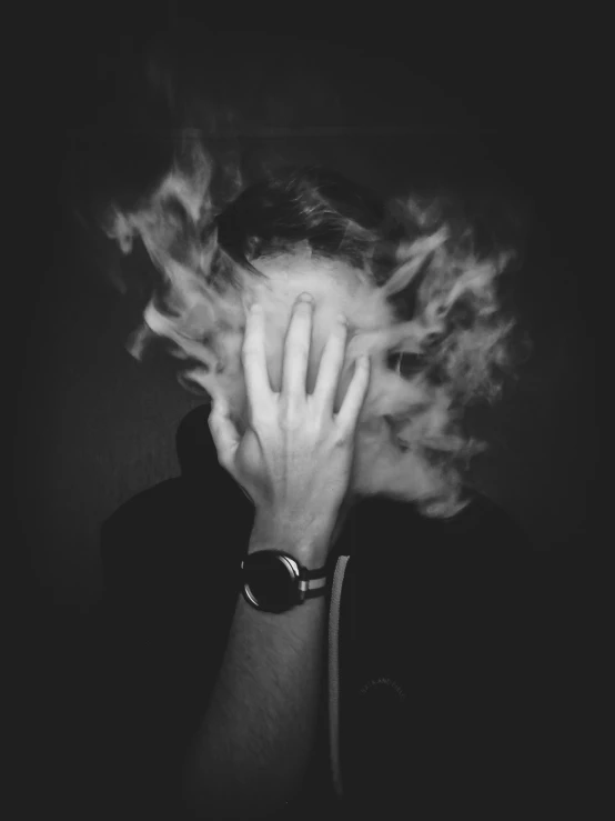 a woman wearing a watch on her wrist covered by clouds of smoke