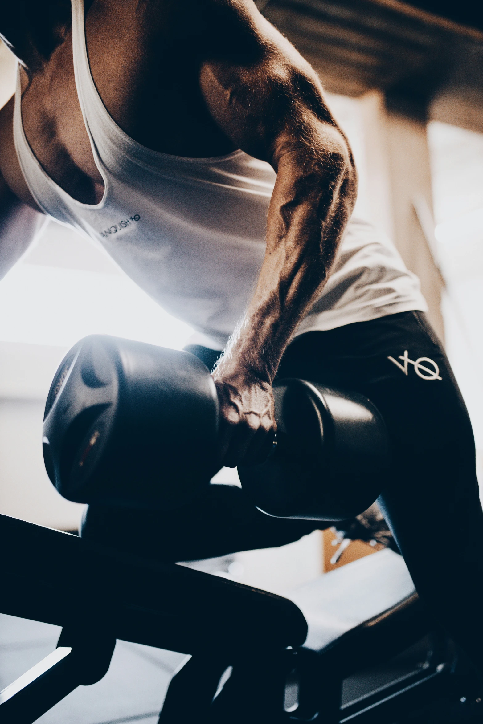 a man in shorts and a tank top doing a sit up on a exercise machine