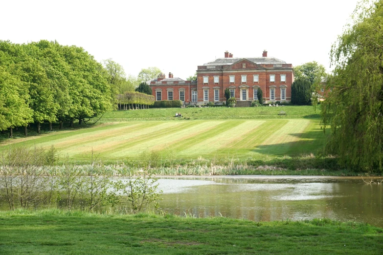 a large brick house is across the river