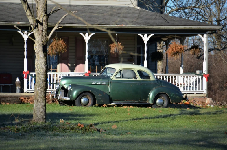 an old car is parked in front of a house