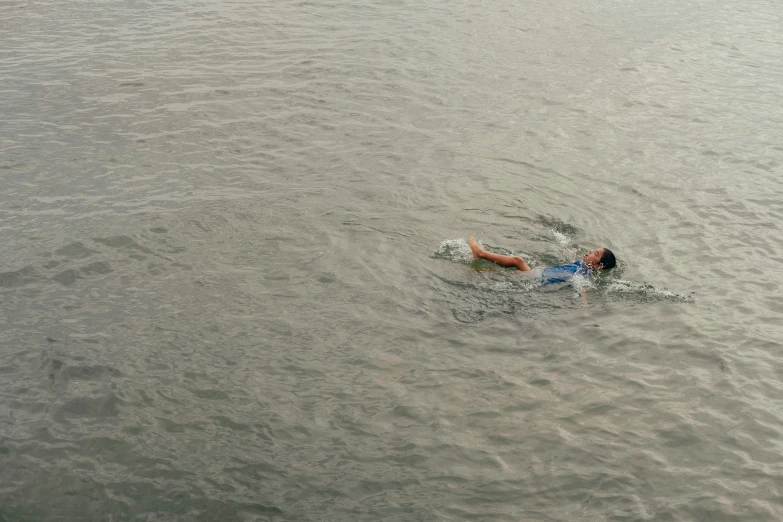 a person floating in a body of water on top of a surfboard