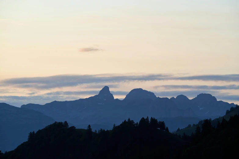 a scenic mountain range, with a single cloud in the sky