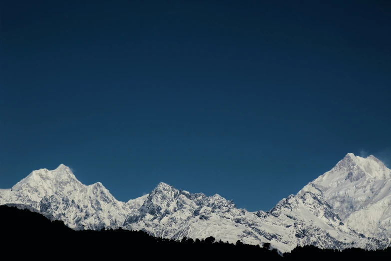 a plane flying past the mountains covered in snow