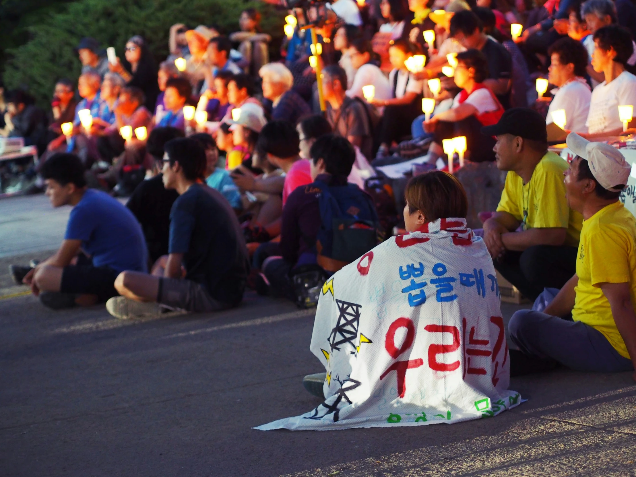 people sitting on the ground in front of some lights