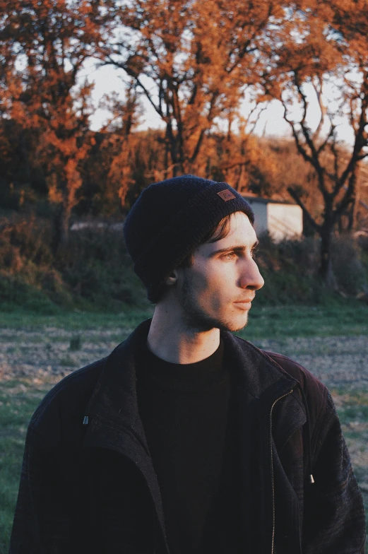 a young man standing in front of a park