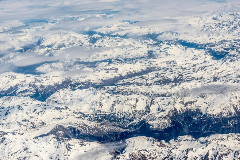 the mountains are covered in snow from an airplane