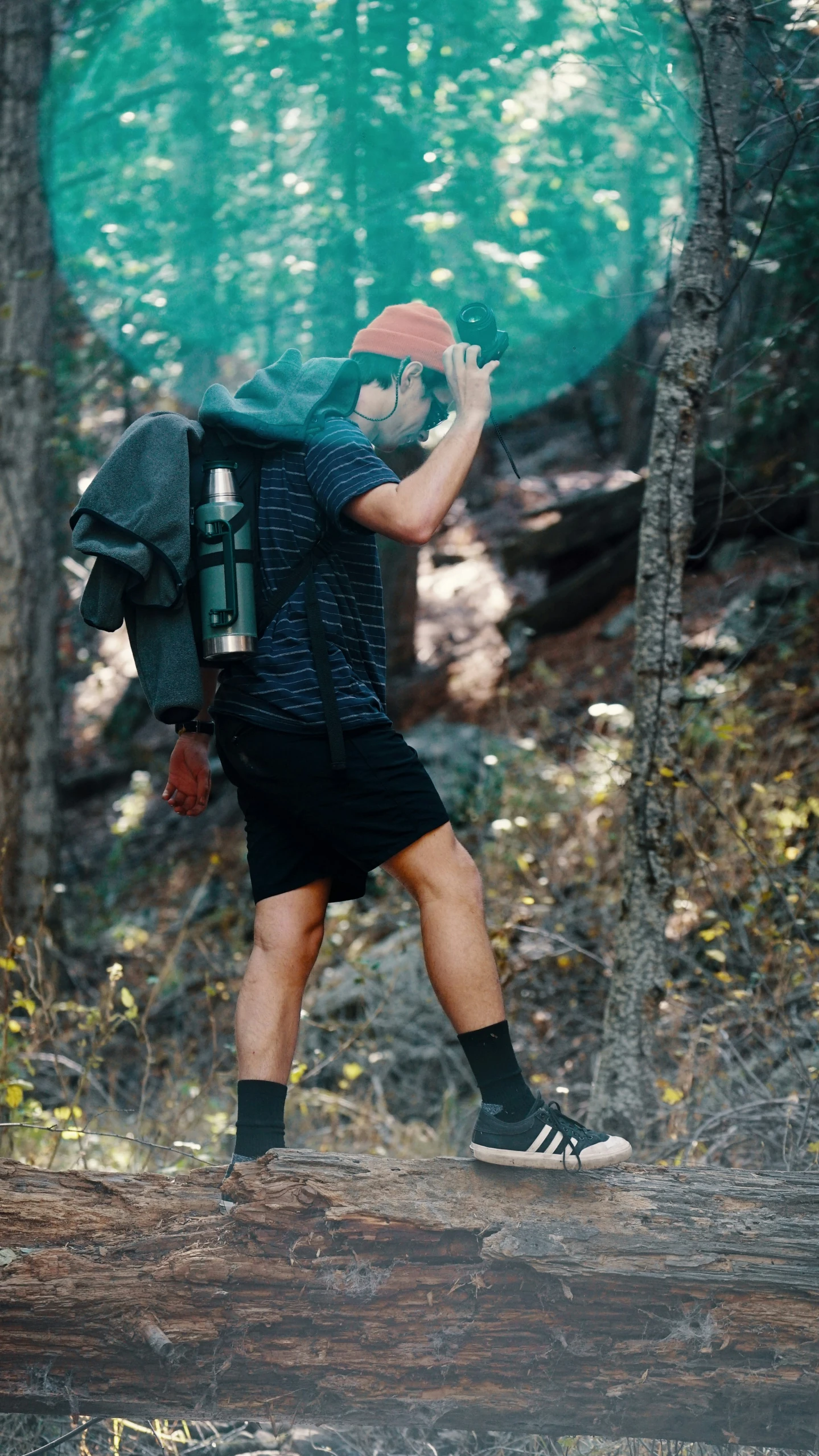 the man is walking across the dirt path with his backpack