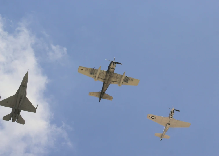 three airplanes flying through a blue cloudy sky