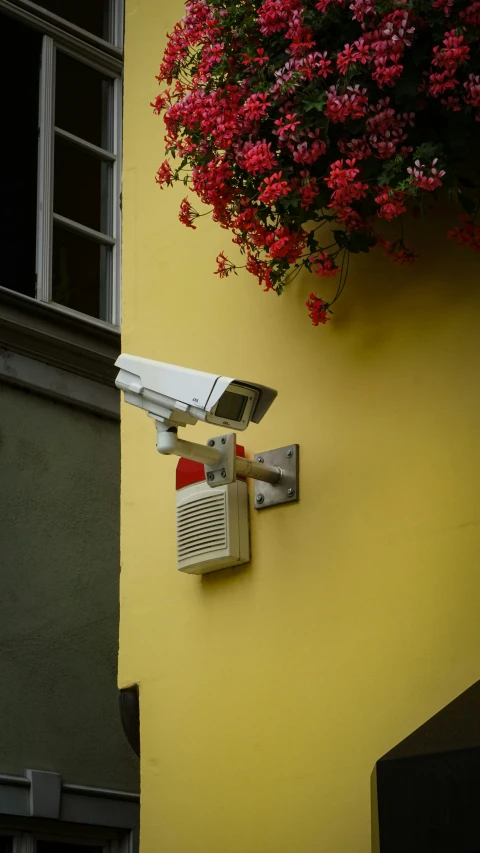 the outside of a house wall has a security camera attached