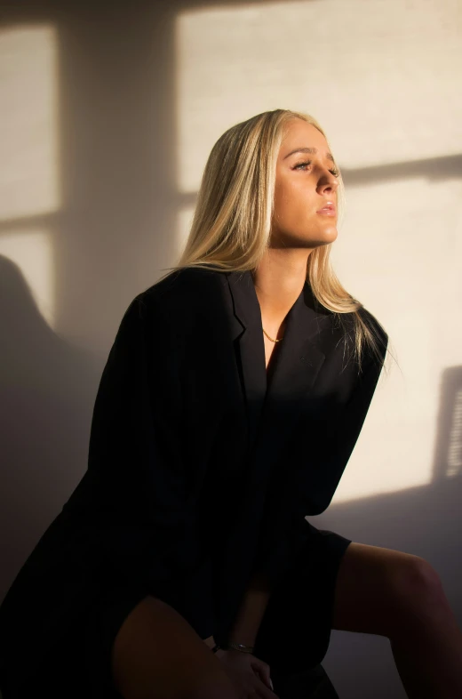 a woman in a black shirt and heels is sitting down