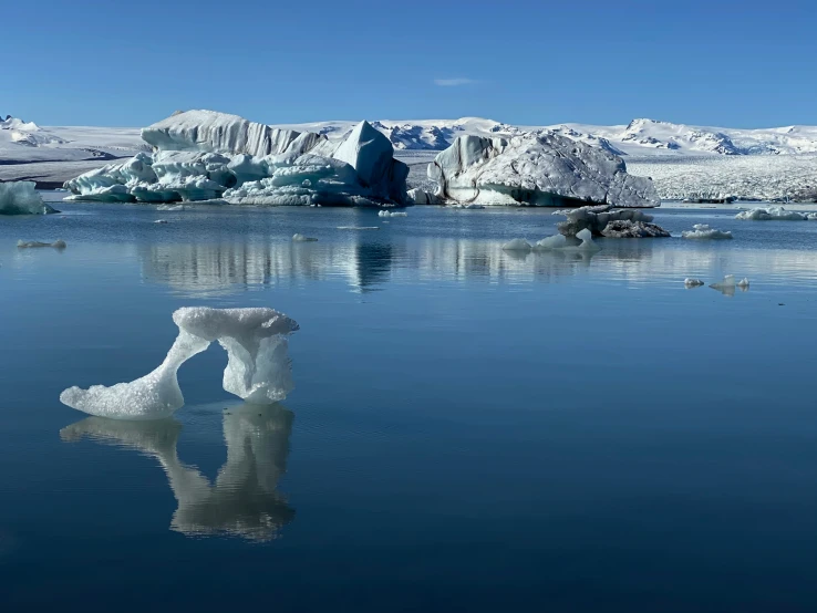 an iceberg is in the water near some hills