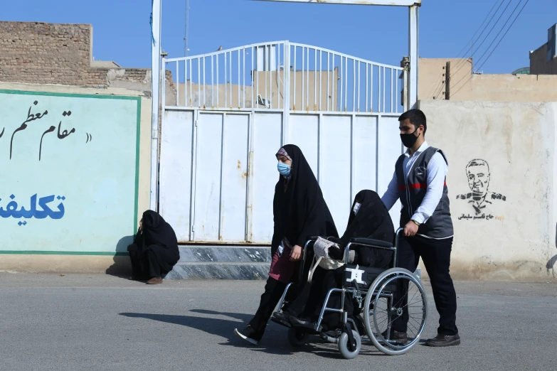 an adult on a wheel chair with a woman in a black and white dress