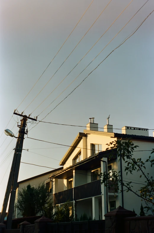 a high voltage telegraph pole in front of some apartment buildings