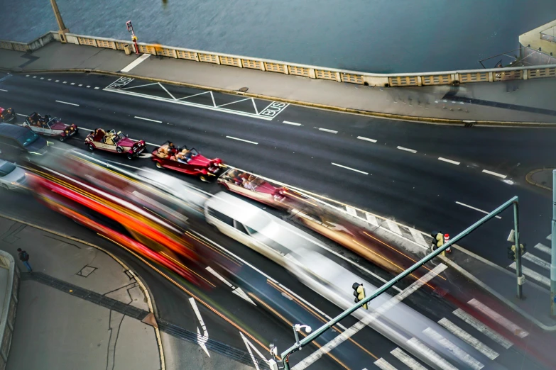 several cars drive down a street near a bridge