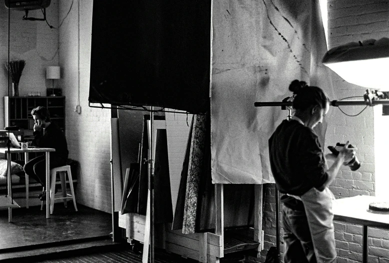 a woman looking over a wall in an art room