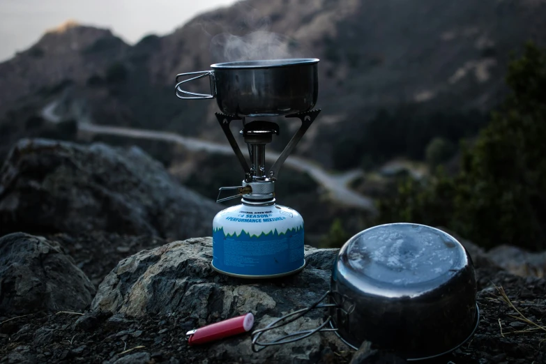 a blue flask gas can with a flame on top of it and another object