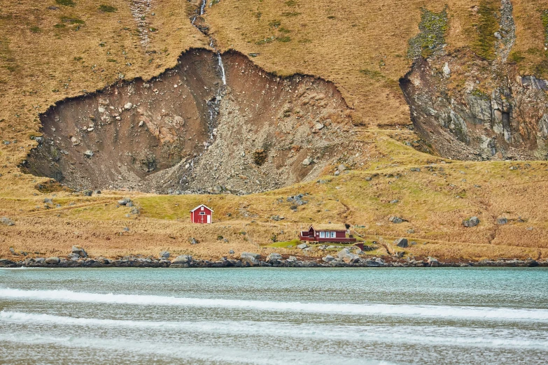 an island of grass and a red house on the beach