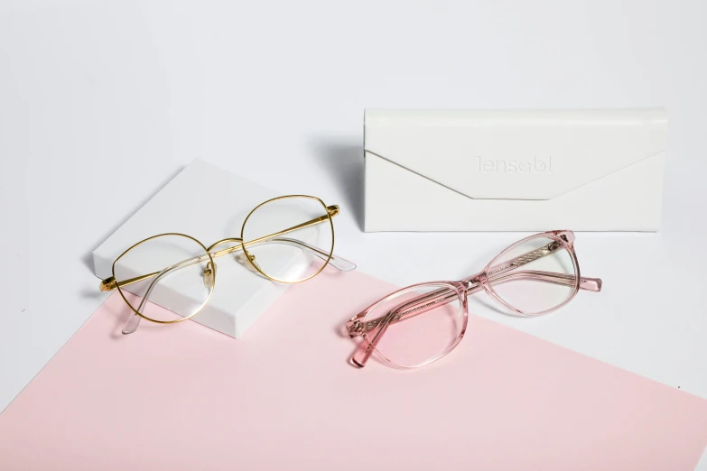 a pair of glasses is lying on top of a pink desk