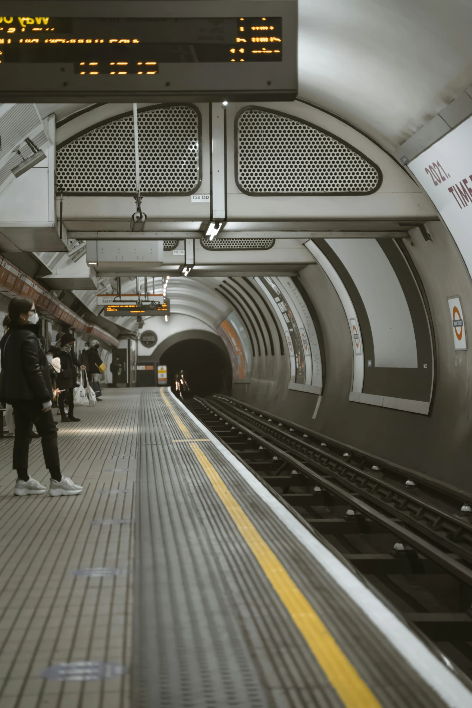 some people are walking in a subway near a platform