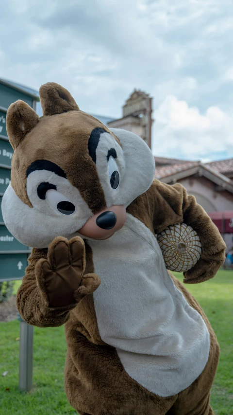 a mascot wearing a mask holds a fan