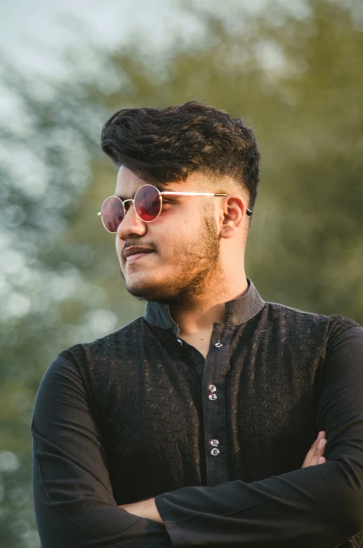 an indian man wearing round red sunglasses and black shirt