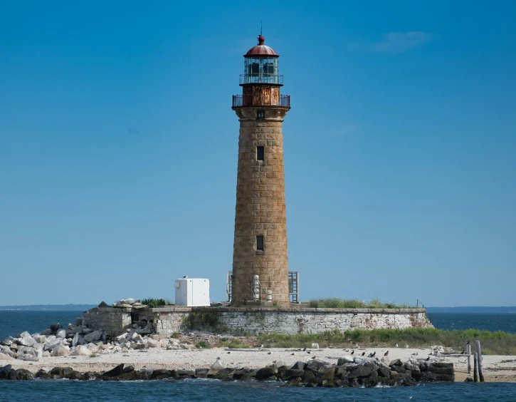 a light house next to a boat on a body of water