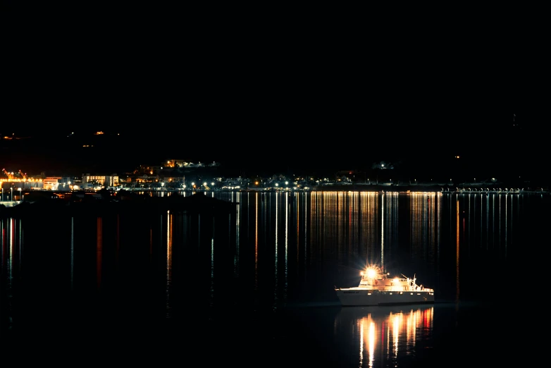 a small boat is sitting out on the lake at night
