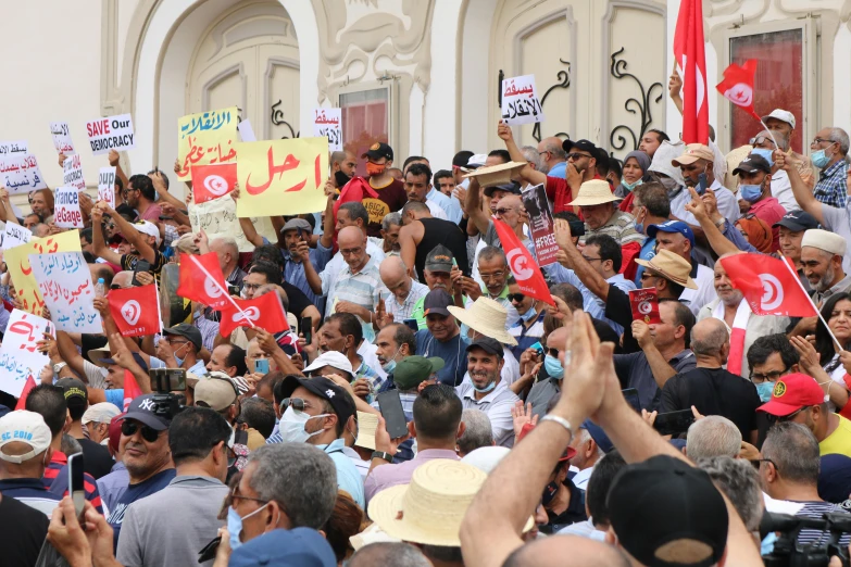 people with hats are holding signs in a crowd