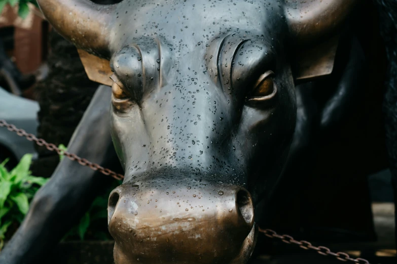 a sculpture of a cow, made out of metal with a chain