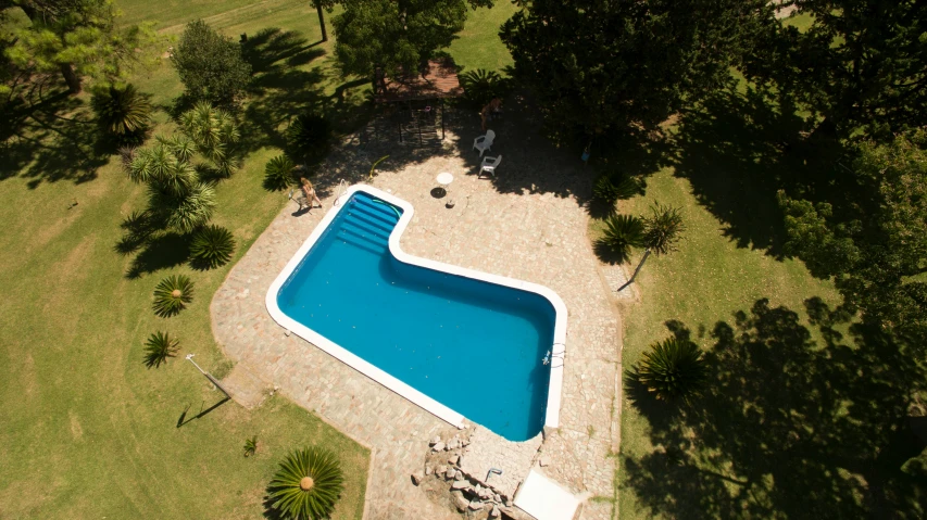 a large pool is seen from above and people around it