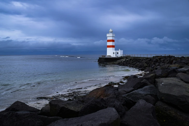 the light house is perched on the small pier next to the beach