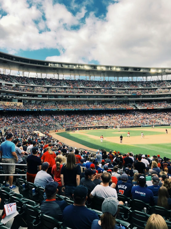 a crowd is watching people play a baseball game in a stadium