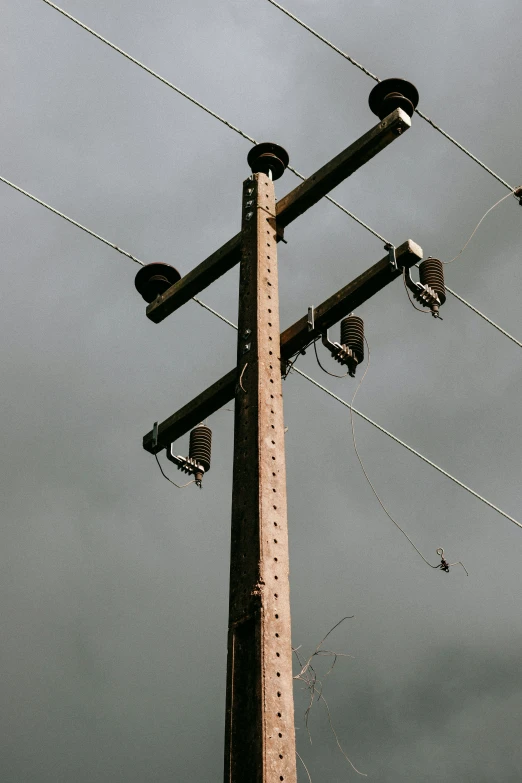 several electric poles with lights and a telephone